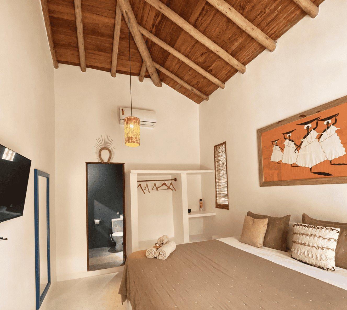 Quarto da Casa Angelina de pé-direito alto, com vigas de madeira aparentes.