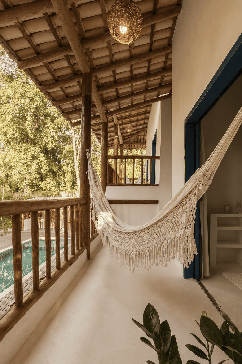 Varanda do Quarto Superior 2 com rede de macramê e vista para a piscina e a mata.