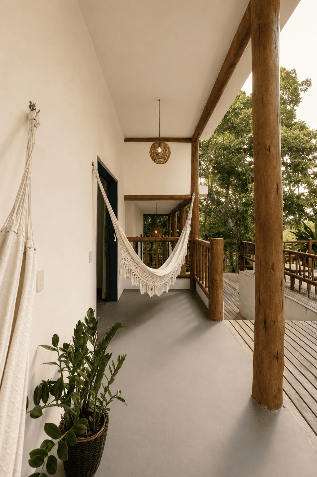 Varanda térrea do Quarto Triplo com rede e vista para o jardim.